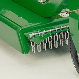 Studio close-up of the corner of a green grooming mower, featuring the end of its safety chain shield
