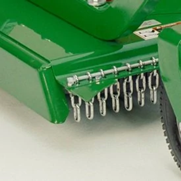 Studio close-up of the corner of a green grooming mower, featuring the end of its safety chain shield