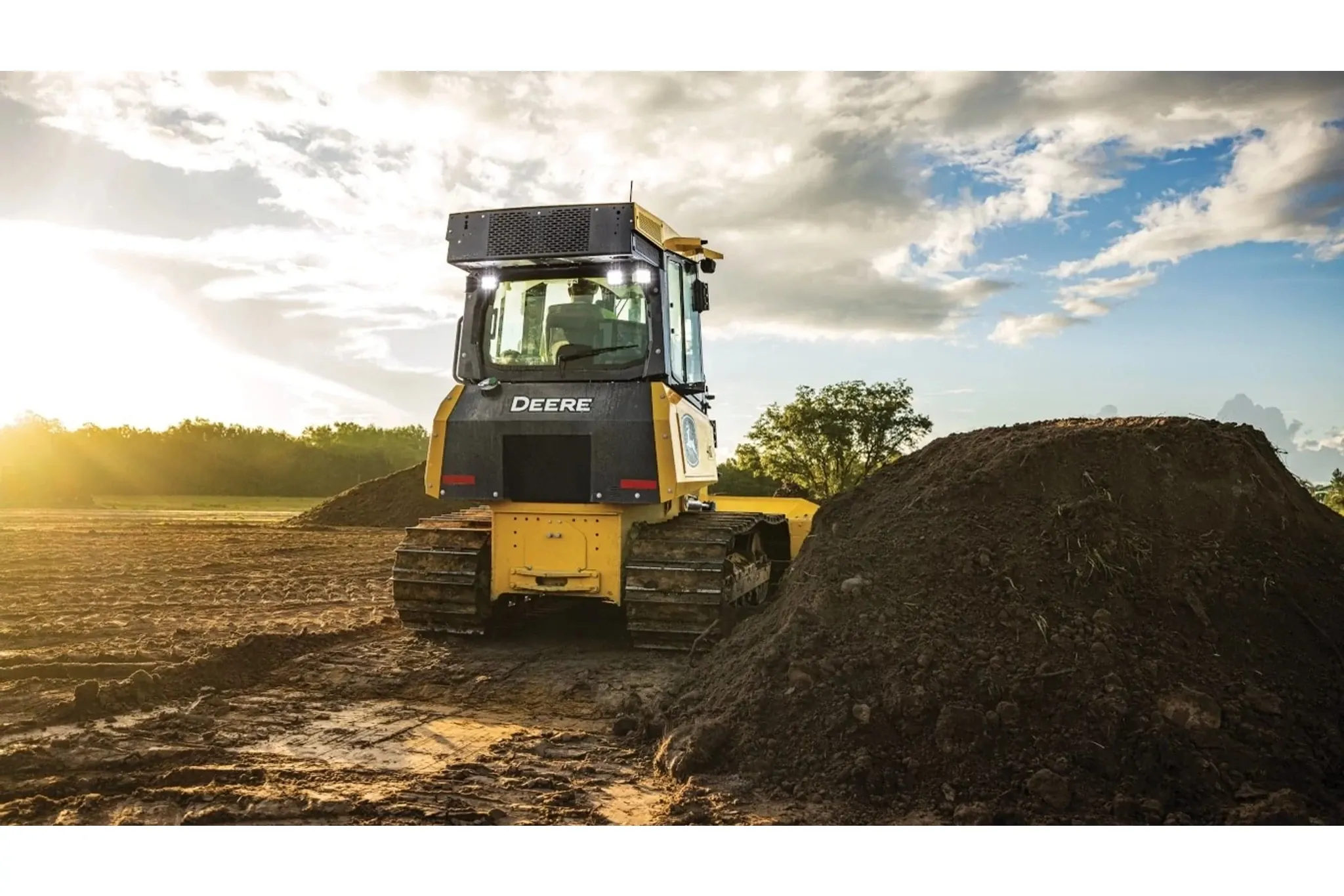 450 P-Tier Dozer next to a pile of dirt in a field