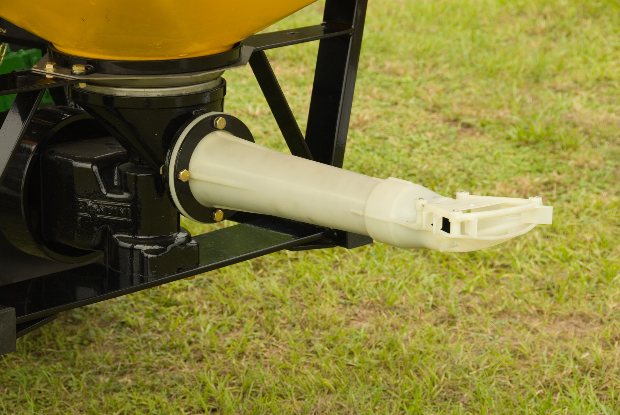 Adjustable nylon spreader spout on the bottom back of a pendular spreader