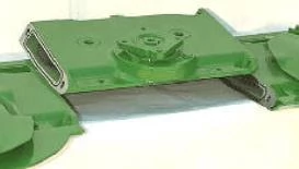 Studio close-up of a diagonal-cut, green cutterbar module lifted above the rest of the bar