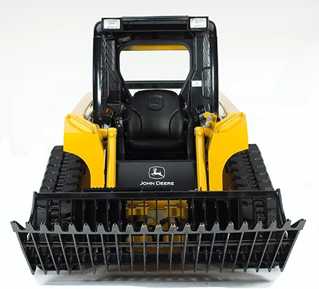 Front studio view of a compact track loader with an R-Series rock bucket attached to the front.