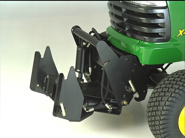 Front left view of a black quick‑hitch mounted on the front of a green lawn tractor, showing the metal frame, hydraulic cylinder, and connection points