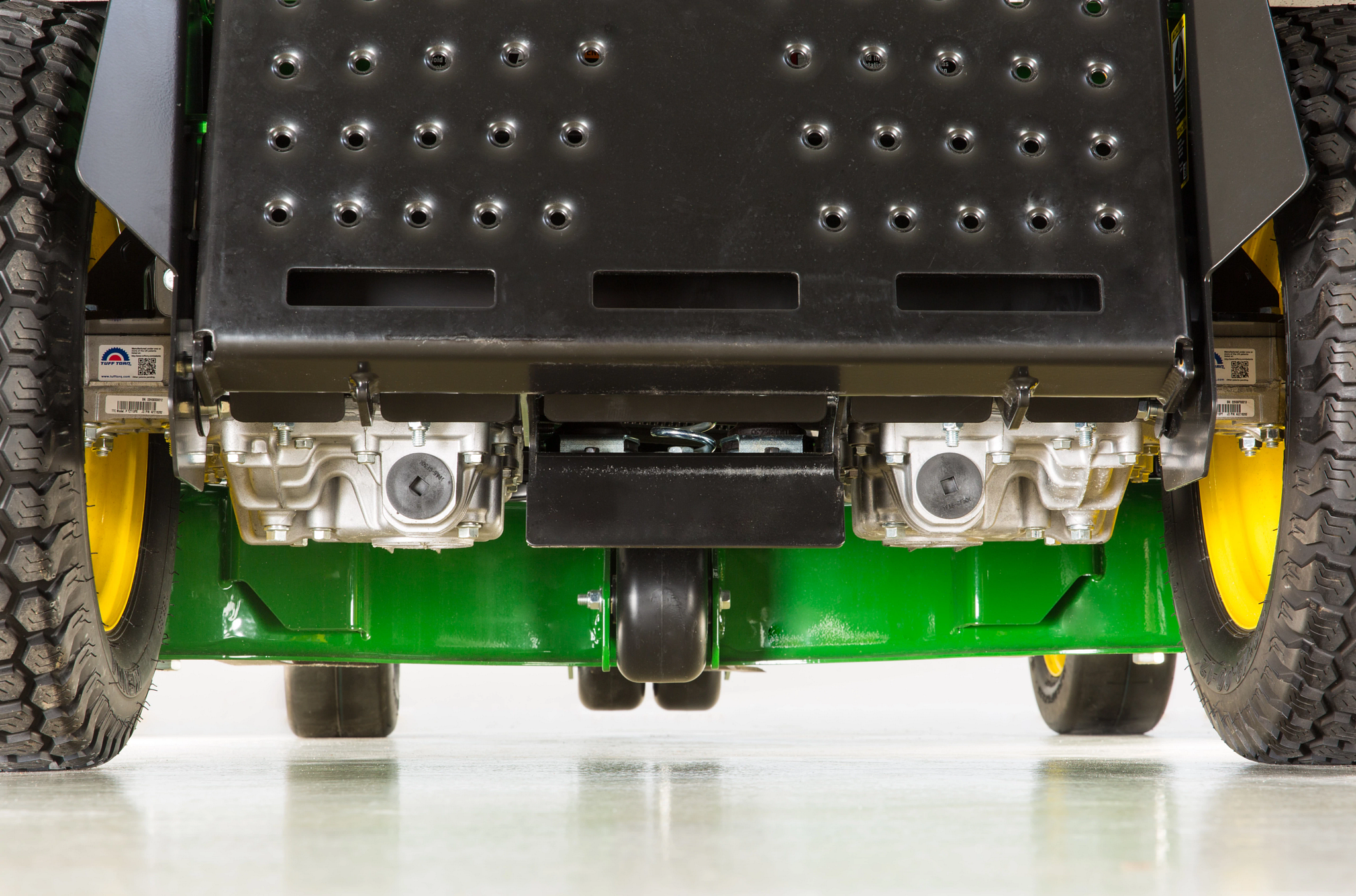 Ground-level image from the rear of a Q820M QuikTrak™ Stand-On Mower with a view of the wheels and Tuff Torq® TZT13 integrated transaxles