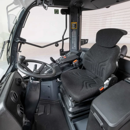 View of a G-Tier loader cab upon entering: black and gray dash, implements, and operator station