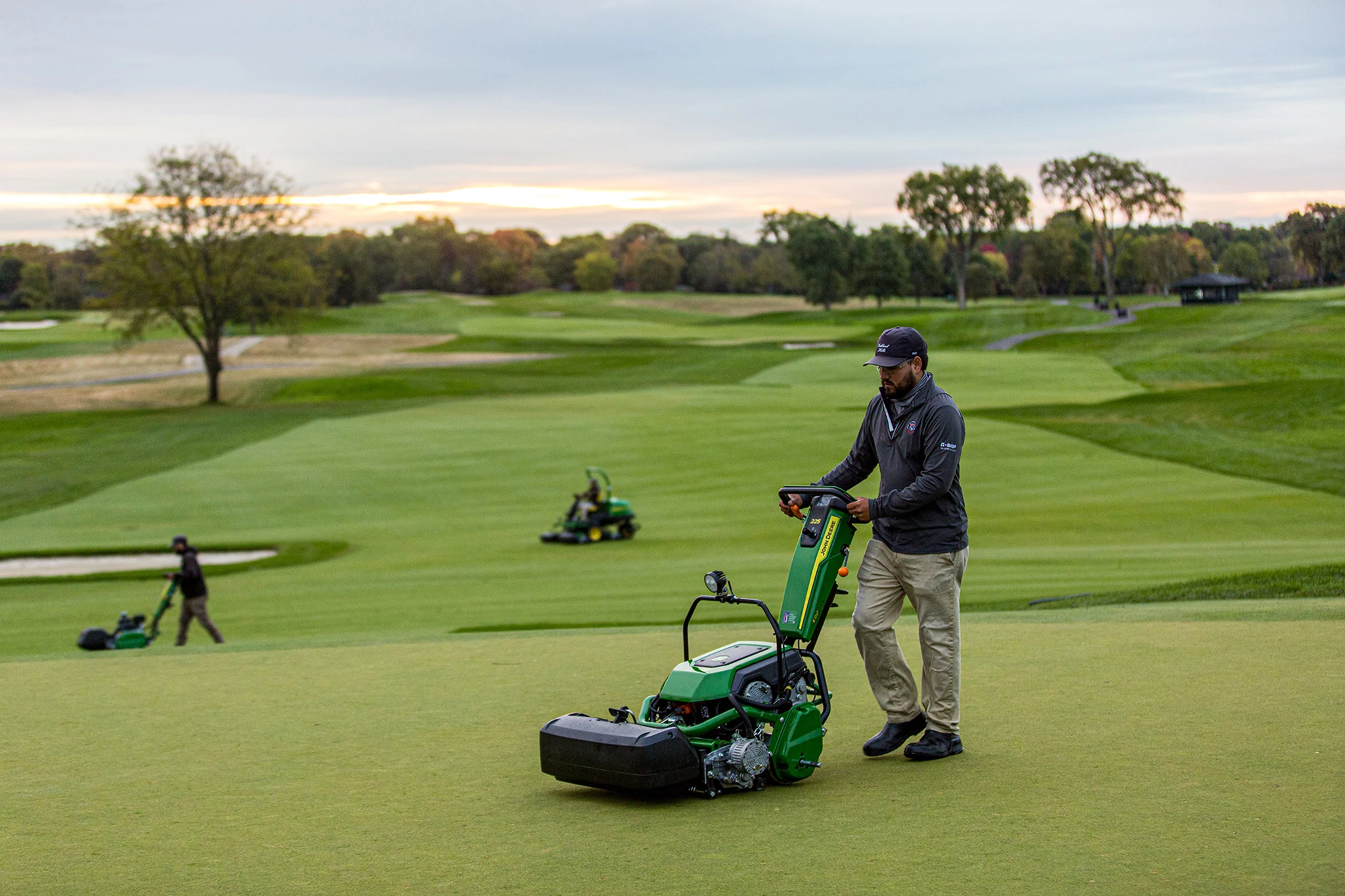 E-Cut Electric Walk Greens Mower being used on a the green of a golf course.