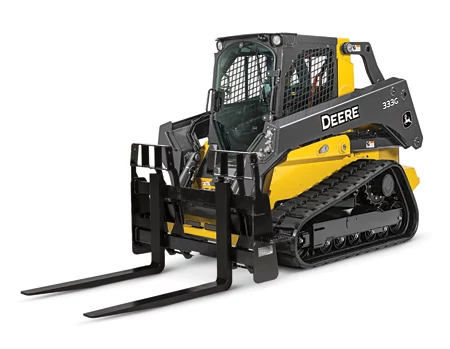 Front left studio view of a 333G compact track loader with attached PF series severe duty pallet fork resting on the floor