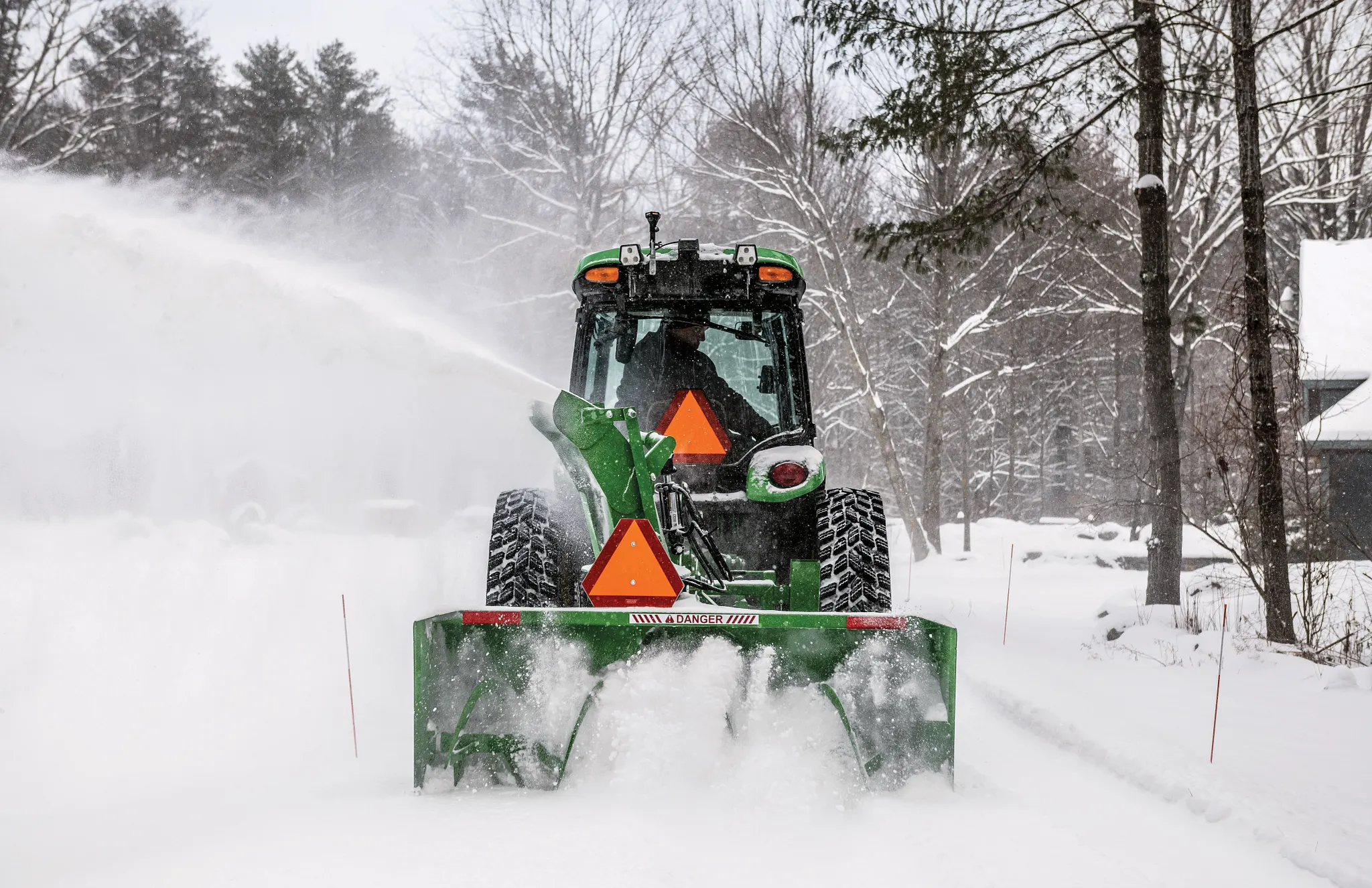 Rear view of a SB1280 Snowblower on a 4075R Tractor blowing snow on a driveway
