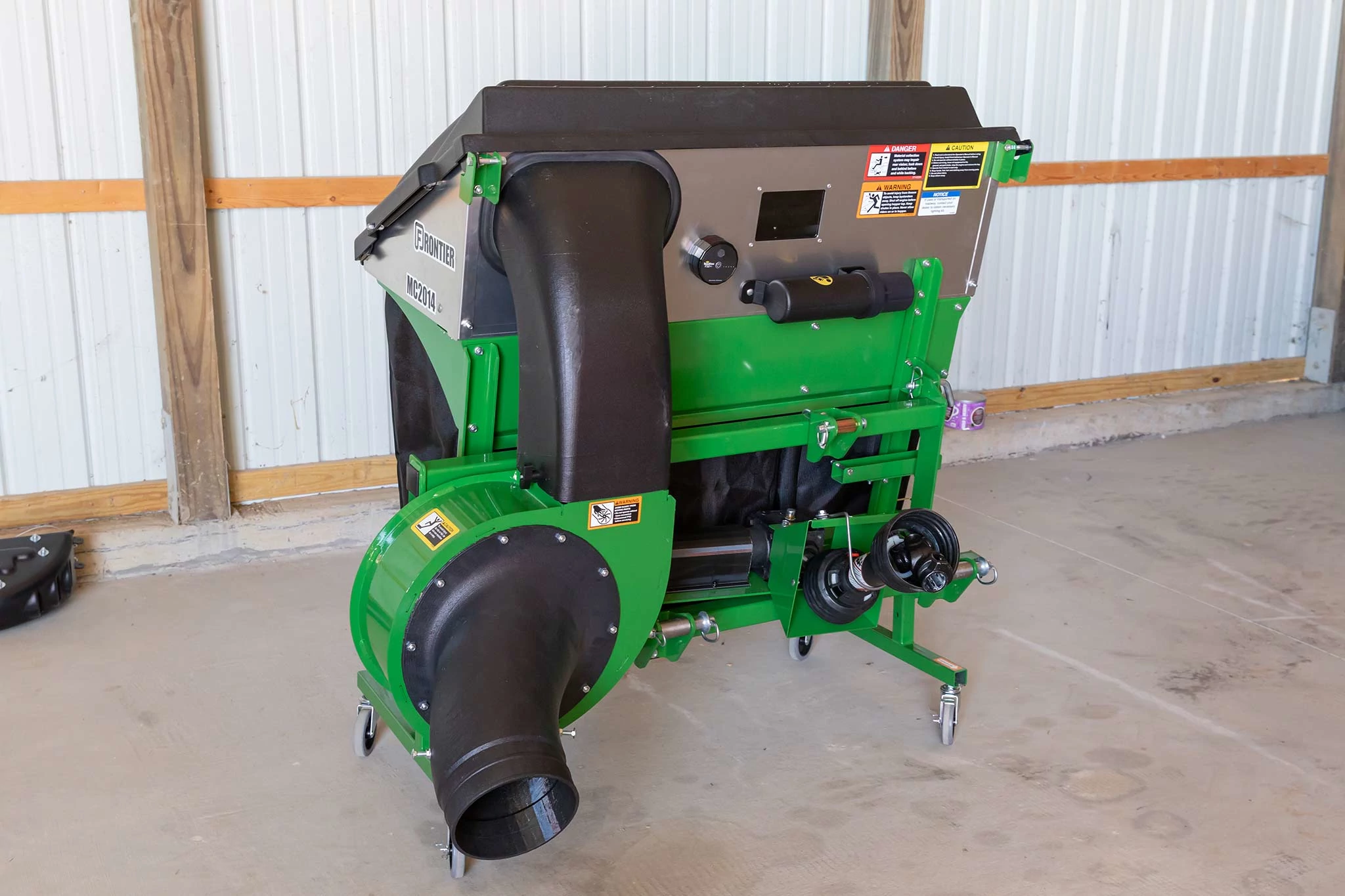 Front view of the back of an MC2014 material collection system, showing the discharge shoots and green housing in a warehouse
