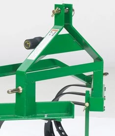Close-up of a green cultivator implement frame featuring mounting points, bolts, and structural supports