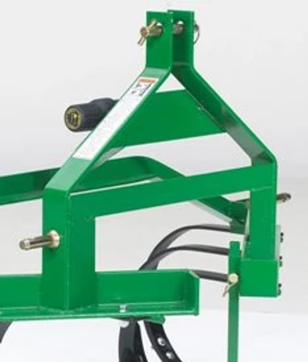 Close-up of a green cultivator implement frame featuring mounting points, bolts, and structural supports