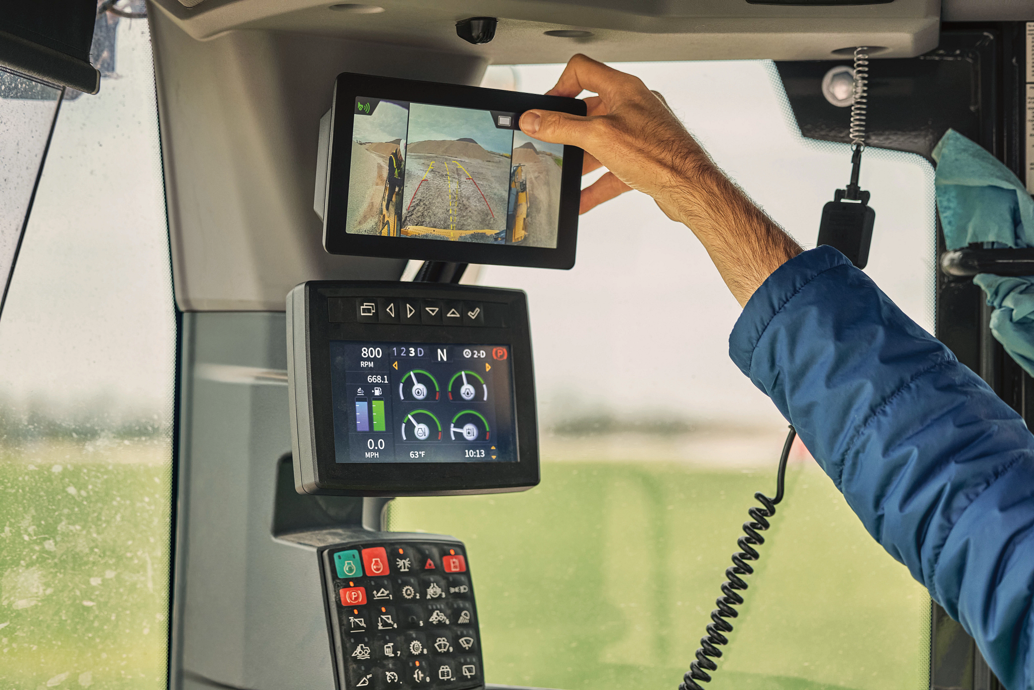 Hand adjusts a monitor in cab