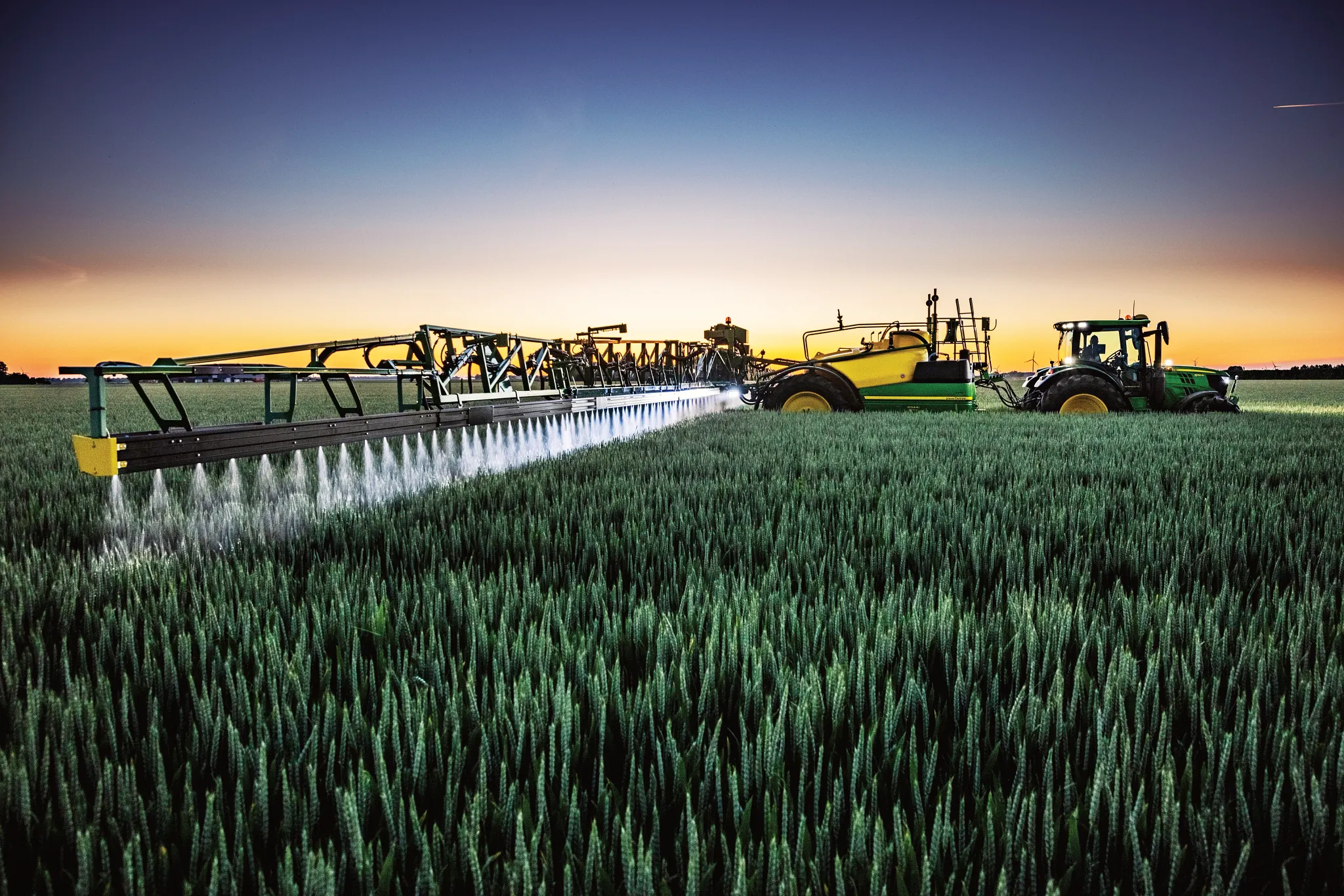 Right side view of a tractor pulling a sprayer in field
