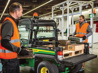 Two men wearing safety vests load crates into the back of a TE 4x2Utility Vehicle