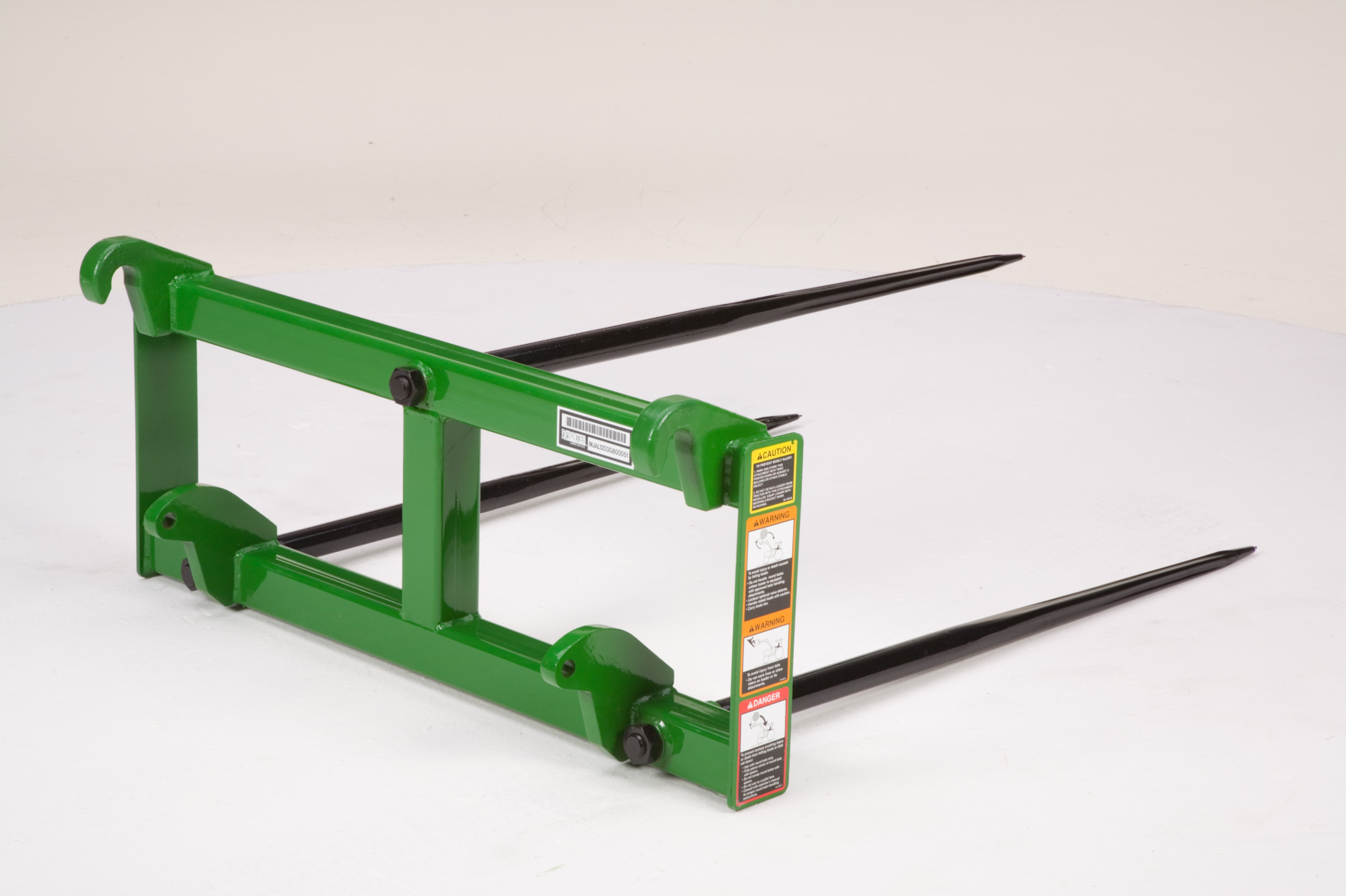 Pallet fork attachment showing the mounting hooks from a front angle with safety labels visible on the frame