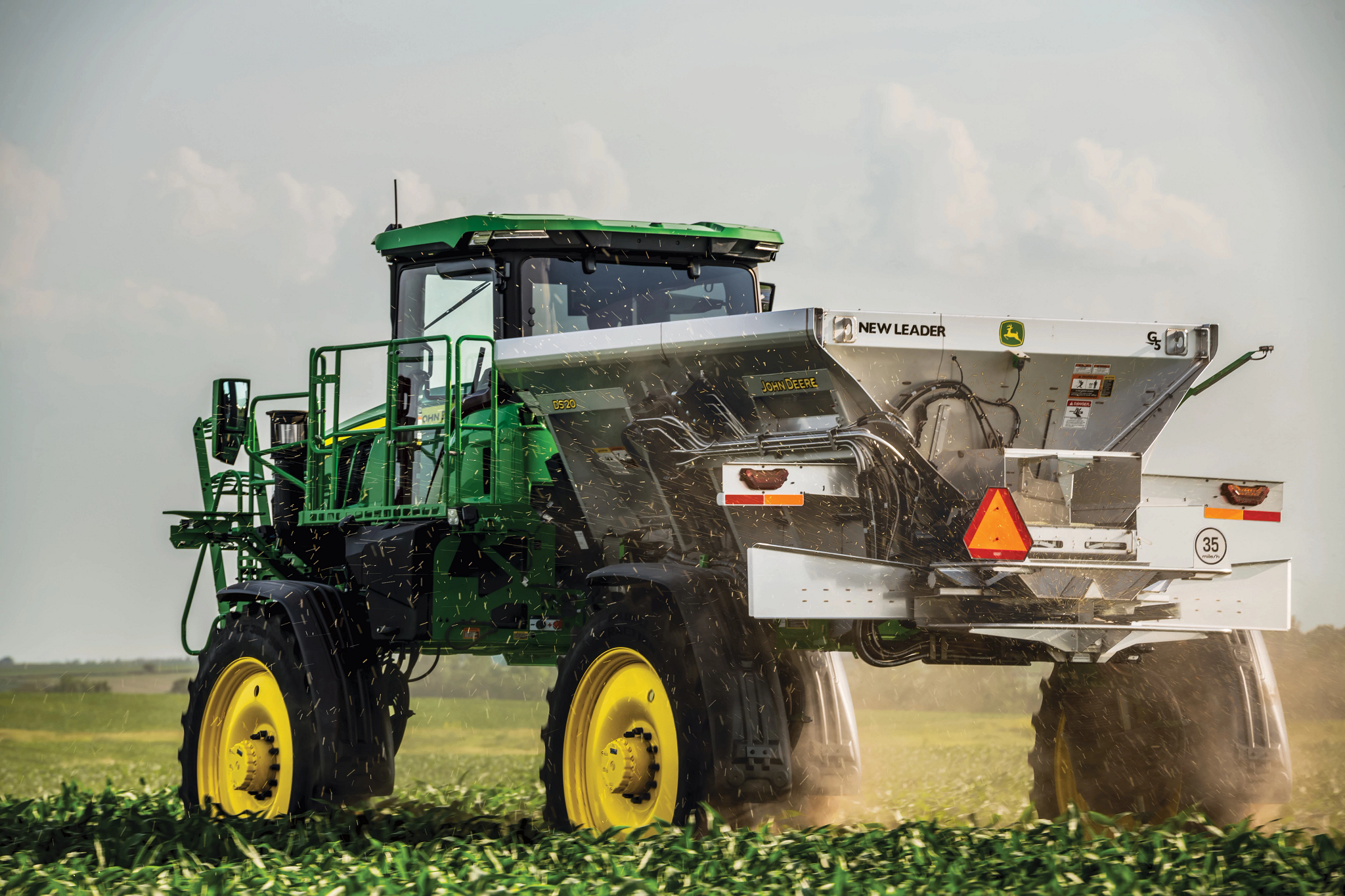 Rear view of a 400R Dry Spinner Spreader operating in a green field with an attached DS20 Spreader.