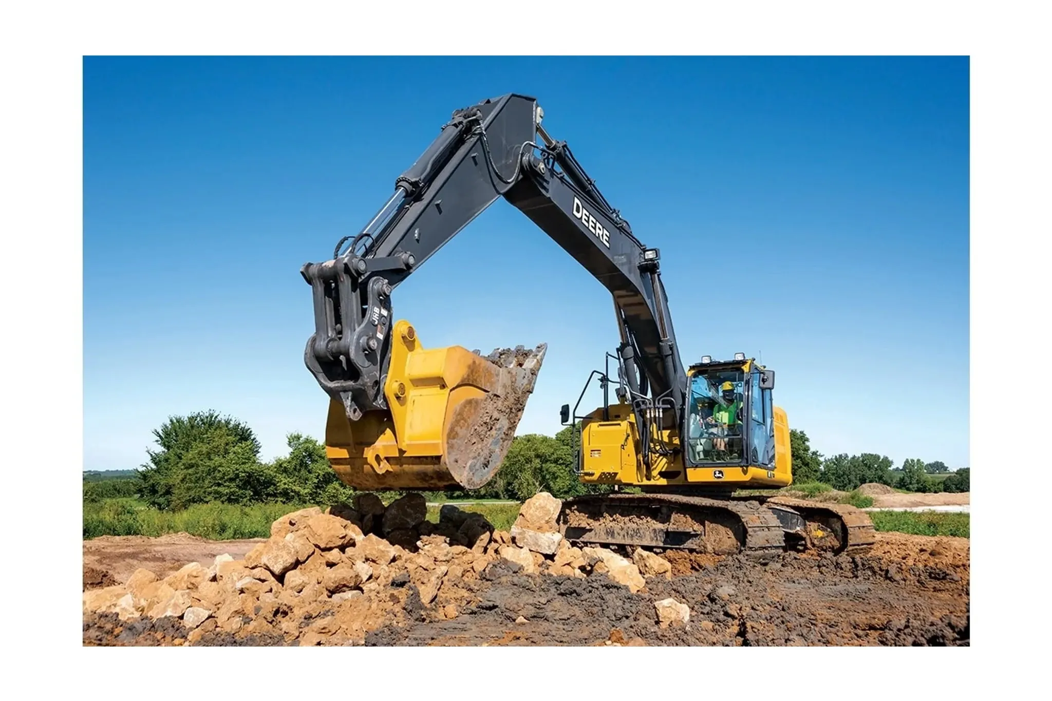 345 P-Tier Compact Excavator moving rocks on a job site