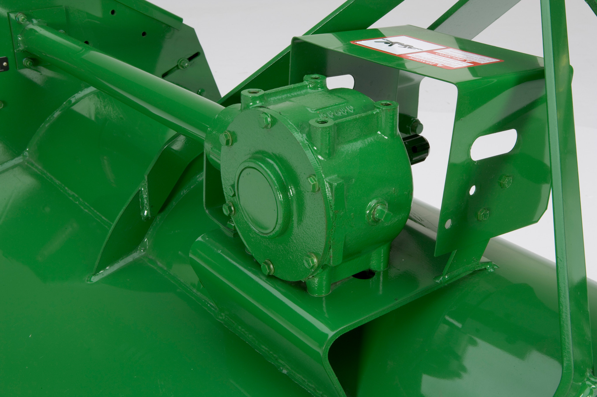 Close-up of gearbox mounted on the deck, with a protective guard and connected drive shaft housing