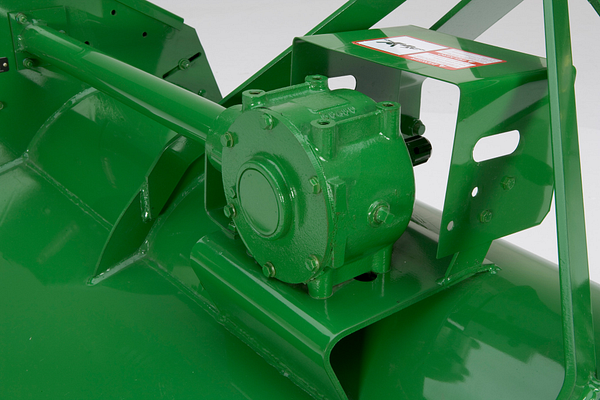 Close-up of gearbox mounted on the deck, with a protective guard and connected drive shaft housing
