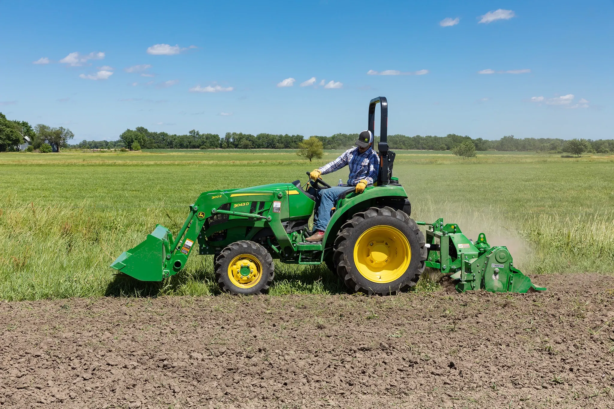 Field view of 3043D Tractor with RT3062 Rotary Tiller and 300E Bucket