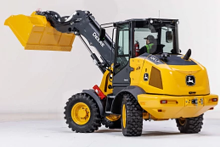 Rear left studio view of a 326 P-Tier compact wheel loader demonstrating Articulation Plus™ steering and raised bucket with tele lift