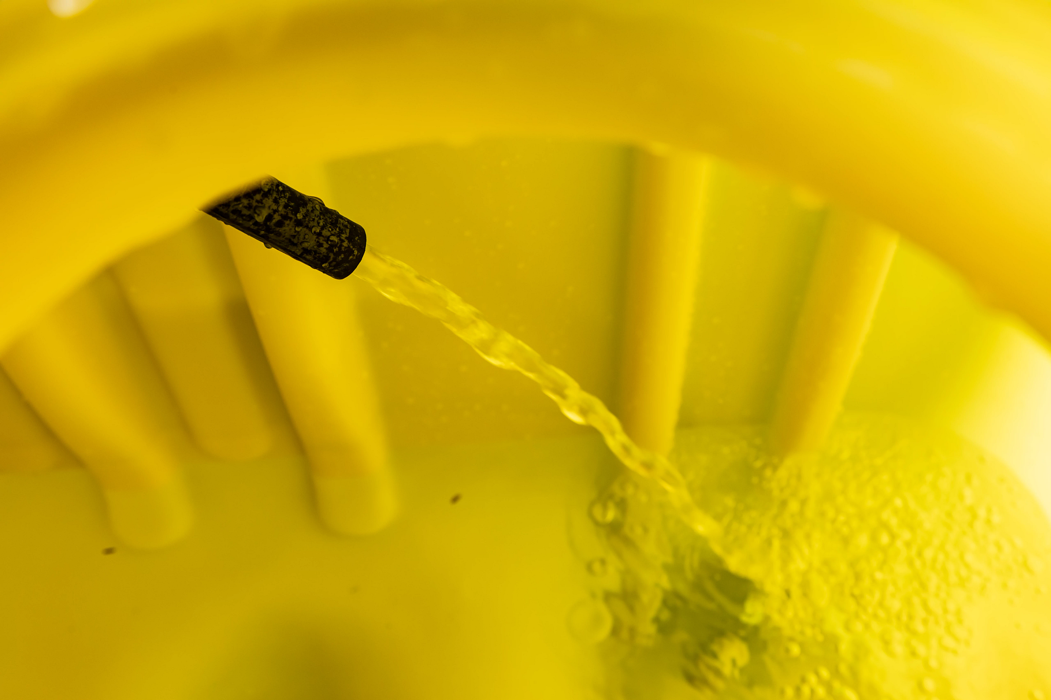 Close-up of the jet recirculation stream within a yellow LS2004 3-Point Mounted Liquid Sprayer's tank