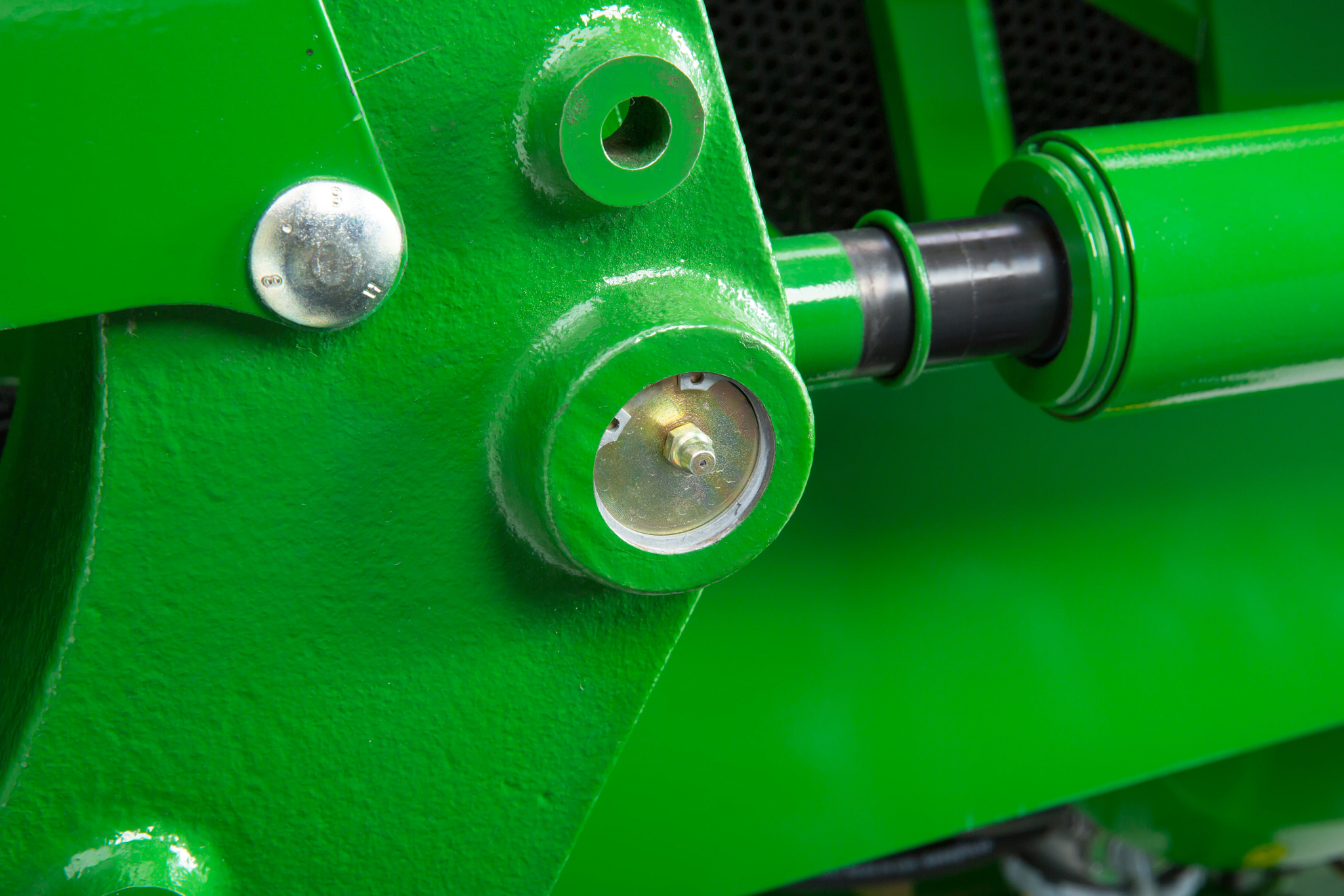 Close-up of end-of-pin lubrication site on a green loader