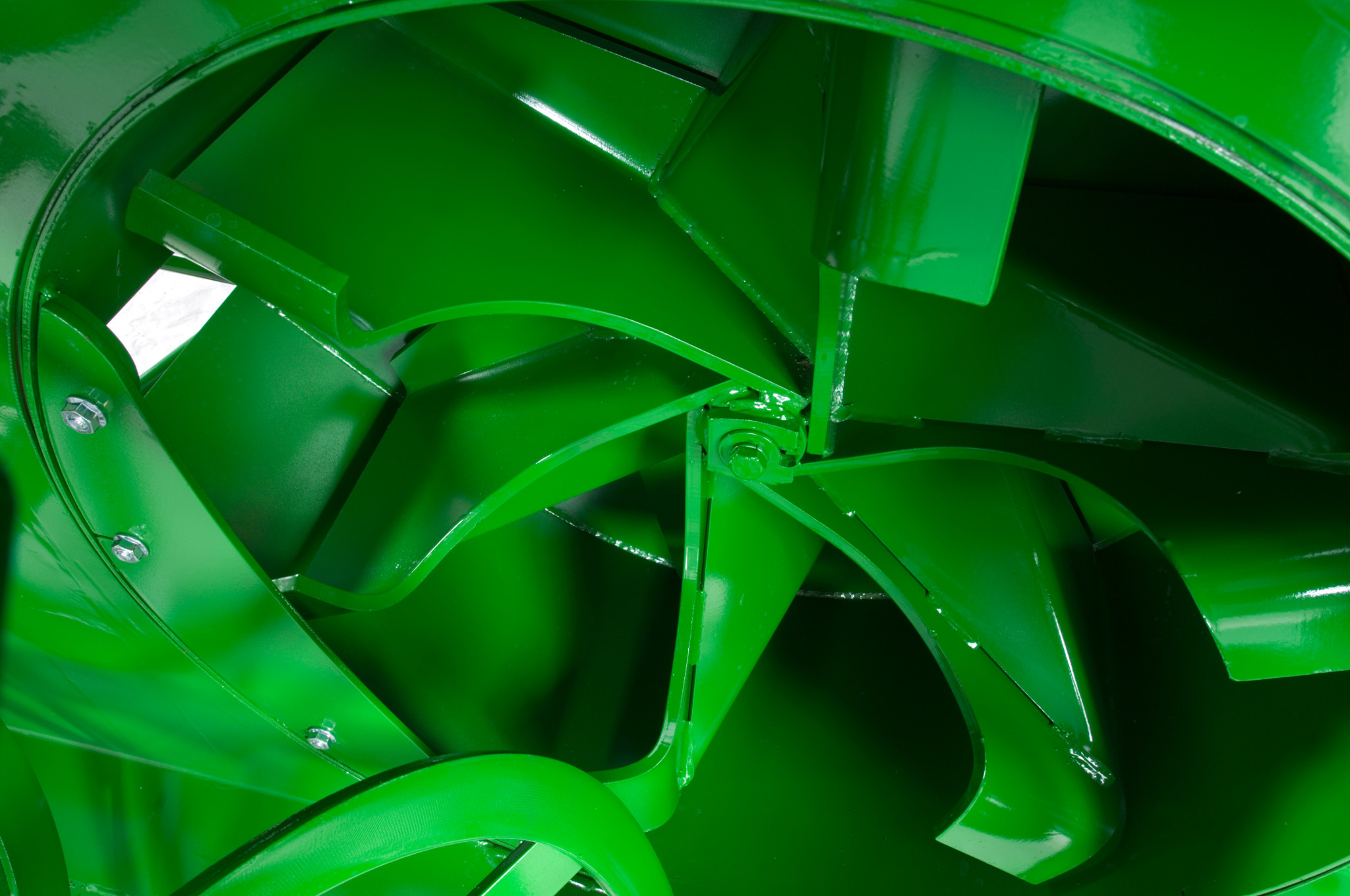 Close-up of the interior of a snowblower showing curved metal paddles and blades arranged around a central hub