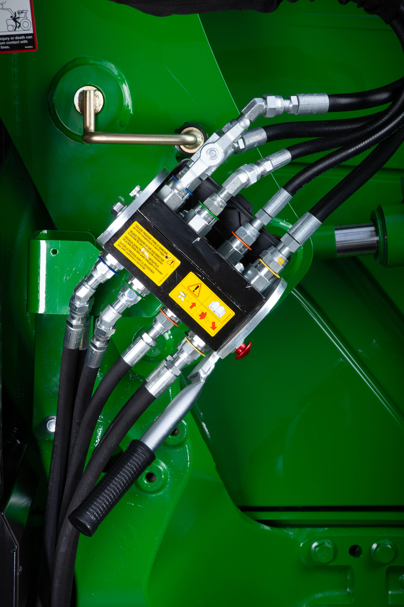 Close-up of a loader's single-point hydraulic connection and lockout valve