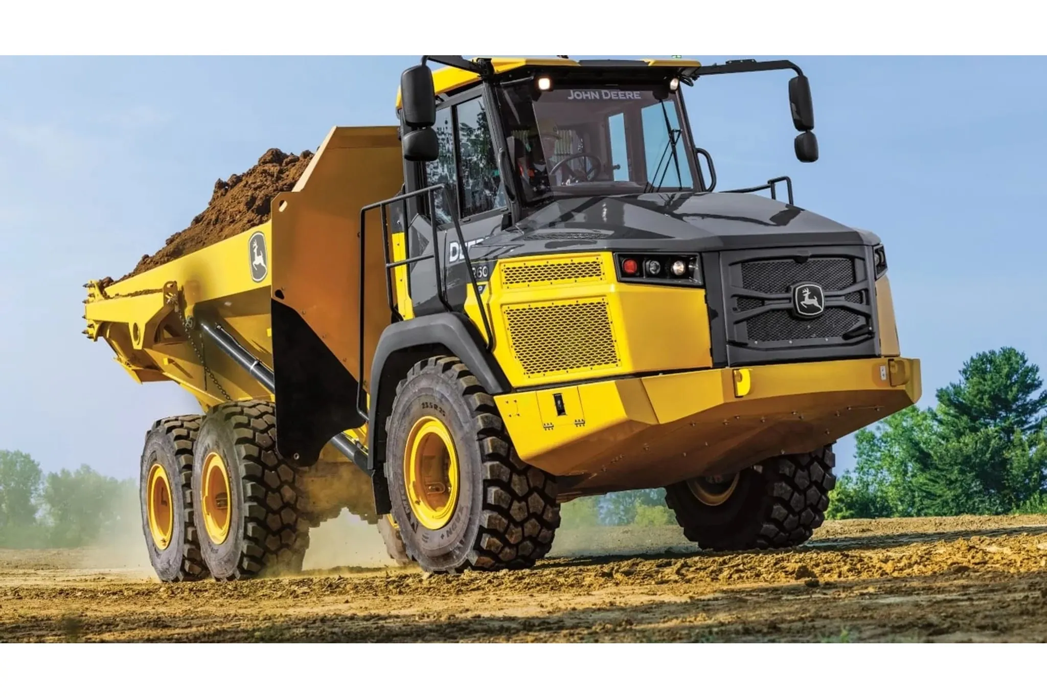 260 P-Tier Articulated Dump Truck driving on dirt road with trees in background