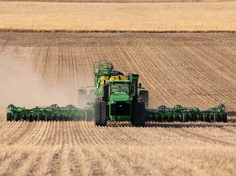 Tractor pulling tillage implement through a field