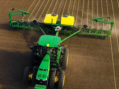 Overhead view of a tractor pulling an implement through a field with AutoPath lines superimposed