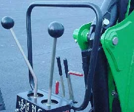 Close-up of a backhoe's external operator station levers and protective bar