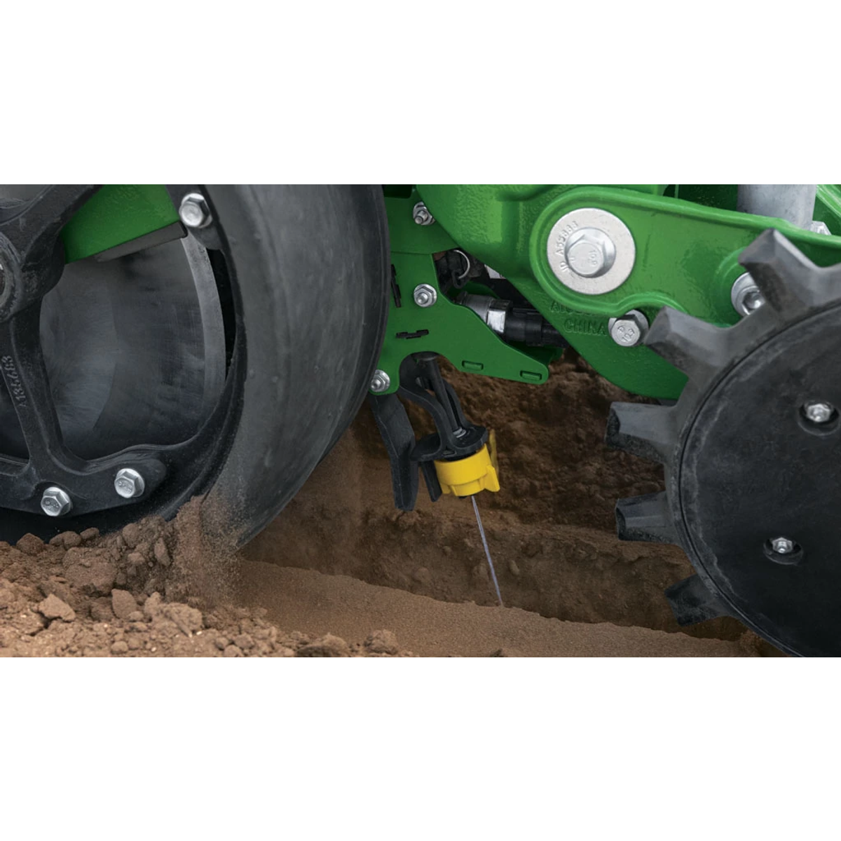 Close-up of a John Deere planter row unit placing seed in the soil — Koenig Equipment