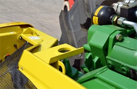 Close-up of yellow and green frame components of a 600 series windrow pick up header's hookup point
