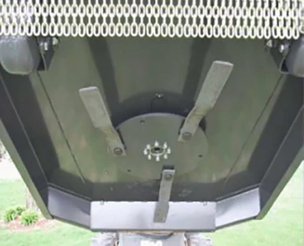 Underside of a rotary cutter, with chain shield across the top and three rectangular blades spaced out in the center