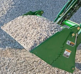 Front left view of an AY11 series 4-in-1 bucket with serrated edge full of gravel