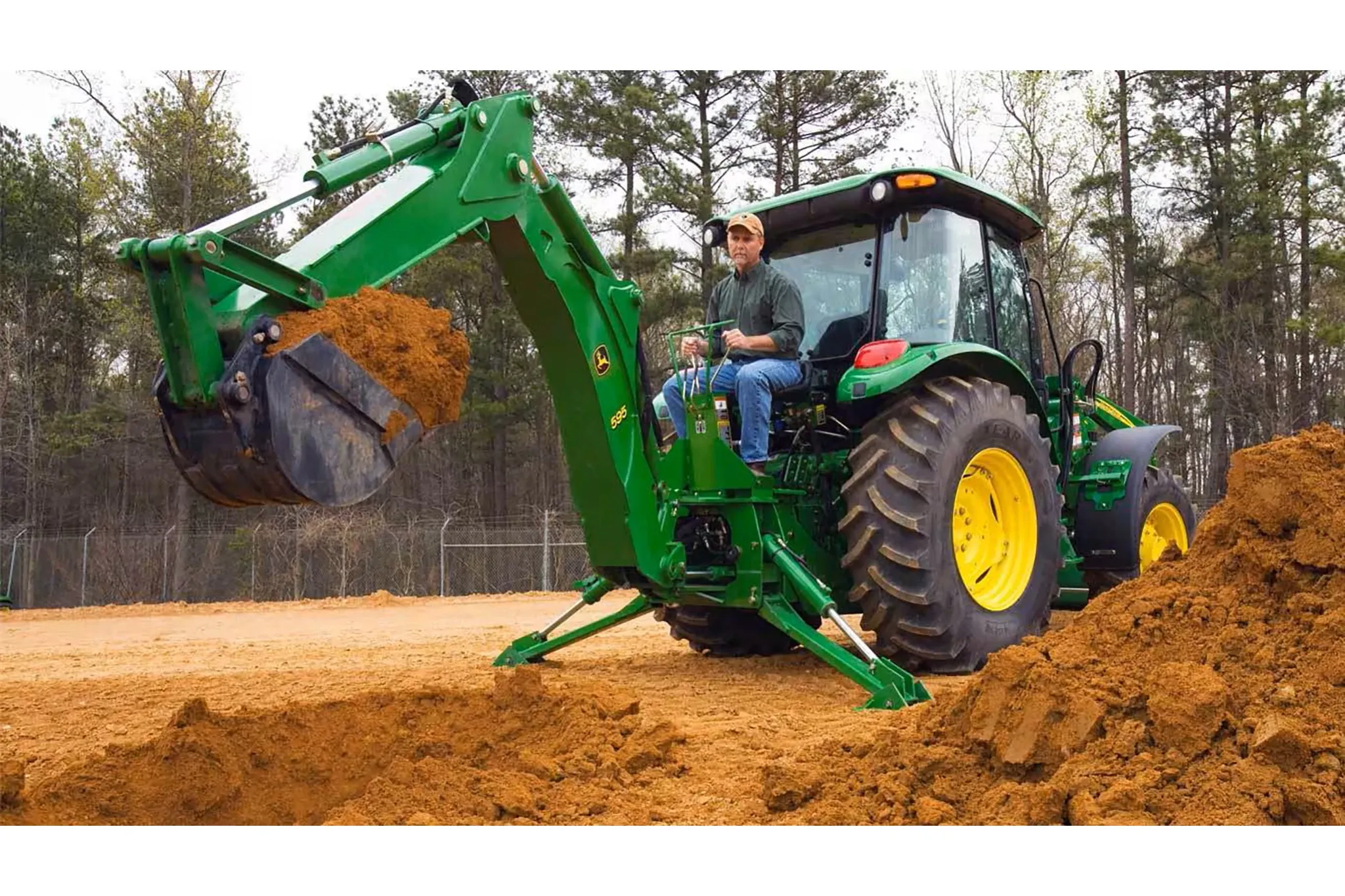 595 Backhoe digging up dirt while attached to a tractor