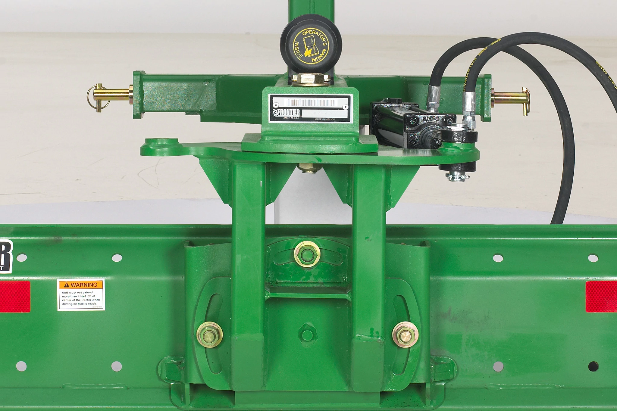 Close-up of the green hitch, pin, and implements on a rear blade necessary for 180-degree blade radius