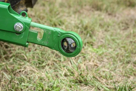 Side, close-up view of a 4M heavy duty tractor's 3-point rear hitch with grass background