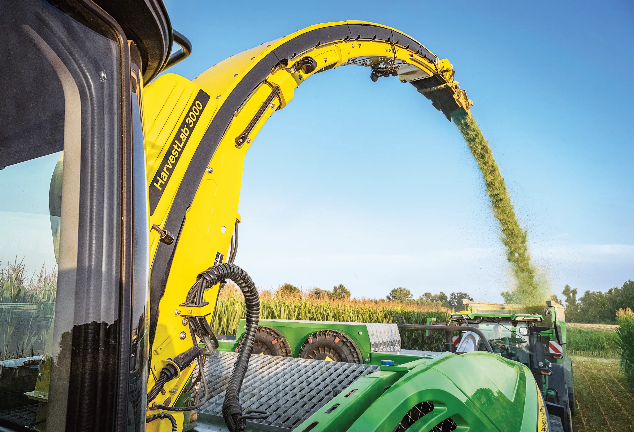 Close-up of spout spraying forage from a Self-propelled forage harvester in the field